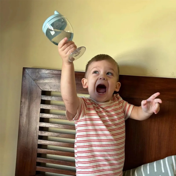 Peuter drinkt zelfstandig uit blauwe WineGlass Sippy Cup – lekvrije baby oefenbeker